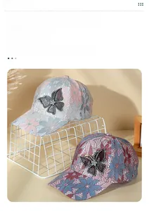 Close-up of elegant lace baseball caps featuring large butterfly patches and rhinestone accents