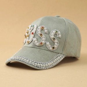 Dettaglio di perle e strass BOSS su un cappellino da baseball in finta pelle verde