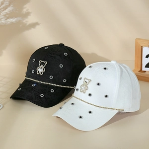 Detail of floral jacquard baseball cap with pearl bear and rhinestone embellishments