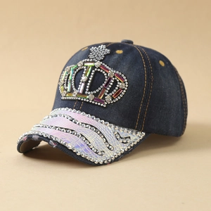 Detail der Jeans-Baseballkappe mit buntem Strass-Kronenmotiv und irisierendem Schlangenmuster-Schirm