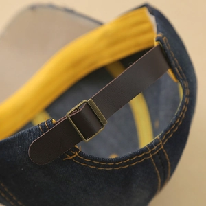 Rückansicht der Denim-Baseballkappe mit Lederriemen und bronzener Metallschnalle