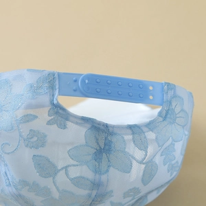 Close-up of adjustable snapback closure on blue lace baseball cap with floral embroidery