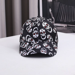 Detail of black baseball cap with white skull patterns and red eye stitch accents