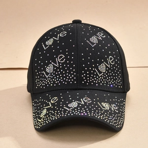 Close-up of sparkling colorful rhinestones forming Love letters on a black baseball cap