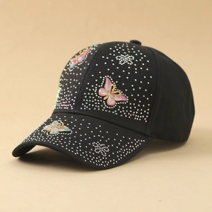 Dettaglio del cappello nero con strass scintillanti e farfalle 3D con sfumature