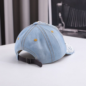 Detail view of denim sun hat with silver rhinestones, sequins, and leather back strap