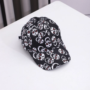 Close-up of black baseball cap with white skull patterns and red eye detailing