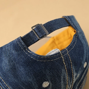 Detailed macro view of denim baseball cap back with metal buckle and yellow lining
