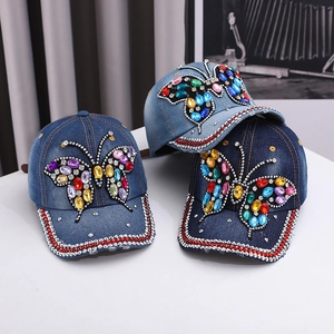 Denim baseball caps featuring colorful rhinestone butterfly designs in various blue washes