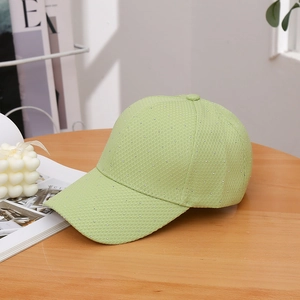 Detail of light green mesh baseball cap with silver rhinestones on a wooden table