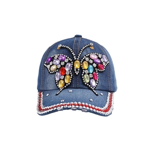Casquette en jean ornée d'un grand papillon multicolore fait de strass brillants