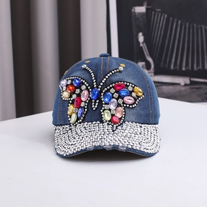 Détail d'une casquette en jean avec papillon en strass colorés et visière scintillante
