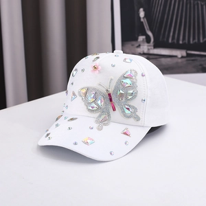 White baseball cap with crystal butterfly rhinestones and pink floral decorations
