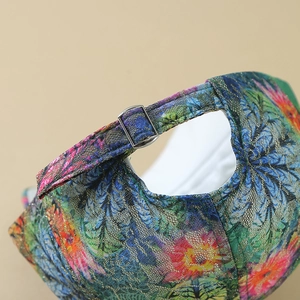 Detail of colorful floral lace baseball cap with sparkling lurex and silver buckle adjuster