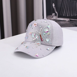 Close-up of a grey baseball cap with colorful butterfly sequins and crystal rhinestones