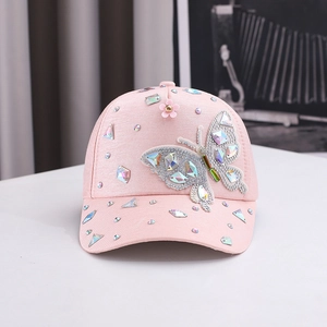 Detail of pink baseball cap featuring 3D flowers, rainbow crystals, and a silver butterfly