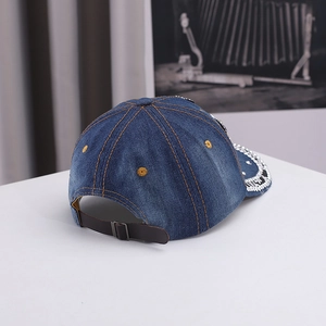 Vue détaillée de l'arrière d'une casquette en denim avec lanière en cuir et strass brillants