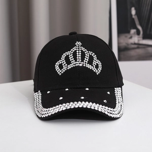 Detailed close-up of crown rhinestone pattern and crystal studs on black cotton baseball cap