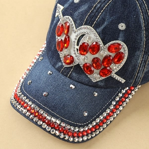 Detail of denim baseball cap featuring rhinestone heart arrows and sparkling brim edges