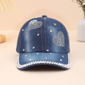 Denim baseball cap with rhinestone heart motifs and studded brim in a cozy home setting