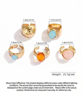 Detailed view of five gold-tone alloy rings with colorful resin gems and adjustable bands