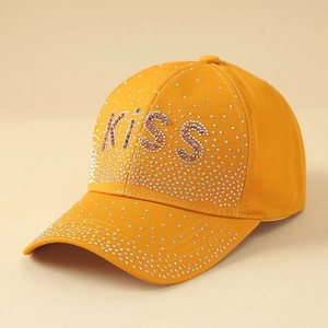 Détail d'une casquette jaune avec lettrage KISS en strass et cristaux étincelants