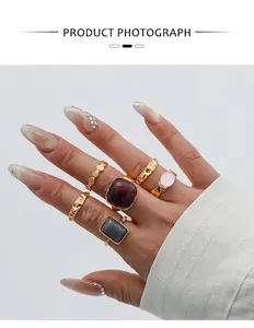 Detail of 6-piece gold alloy ring set featuring purple and grey square gemstones