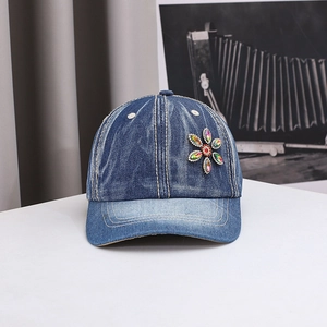 Detail of colorful rhinestone sunflower on vintage washed denim baseball cap