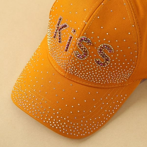 Détail de casquette orange avec strass scintillants et lettrage KISS décoratif