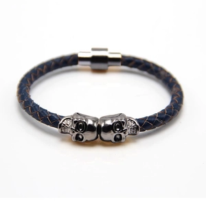 Close-up of navy blue braided leather bracelet with silver metal skulls and magnetic clasp