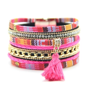Detail showing bohemian layered bracelet with red ethnic fabric, rhinestones and pink tassel