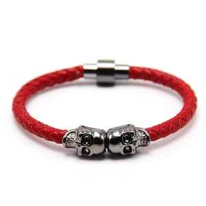Detail of red braided leather punk bracelet with silver skull charms and magnetic clasp