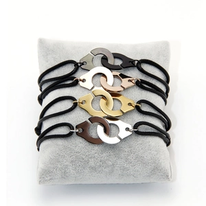 Detail showing four braided handcuff bracelets in black, rose gold, gold, and silver finishes