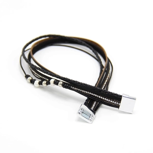 Détail du bracelet multicouche en cuir avec cristaux blancs et fermoir magnétique