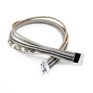 Détail d'un bracelet multicouche en cuir avec perles, strass et fermoir magnétique