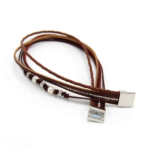 Détail du bracelet multicouche en cuir avec perles, strass et fermoir magnétique