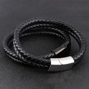 Detail view of multi-layer black braided leather bracelet with silver magnetic buckle