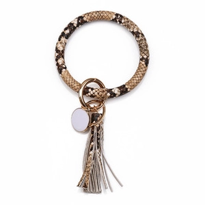 Detail of snake print PU leather wristlet keychain with gold metal clasp and long tassel