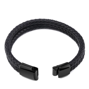 Close-up of black braided leather bracelet featuring a polished magnetic metal clasp