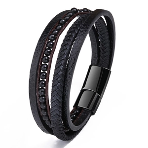Detail of multi-layer men's black leather braided bracelet with matte beads and magnetic clasp