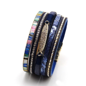 Detail of bohemian multilayer wrap bracelet featuring blue straps and crystal magnetic clasp
