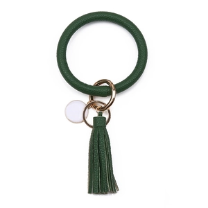 Gros plan sur bracelet porte-clés en cuir PU vert foncé texturé avec gland doré chic