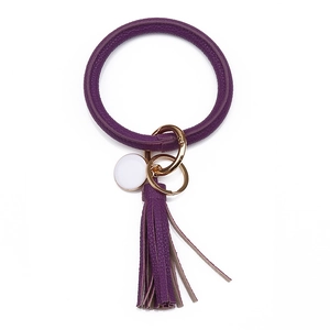 Détail d'un porte-clés en cuir PU violet avec long gland et fermoir doré chic