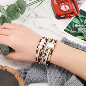 Detail of layered wrap bracelet featuring leopard print leather and golden pearl accents