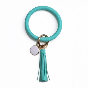 Détail du bracelet porte-clés en cuir PU turquoise avec gland et anneau en métal doré
