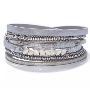 Detail of bohemian multilayer bead bracelet featuring silver metal accents and grey cords