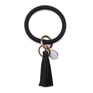 Détail d'un bracelet porte-clés en cuir PU noir avec gland et quincaillerie dorée