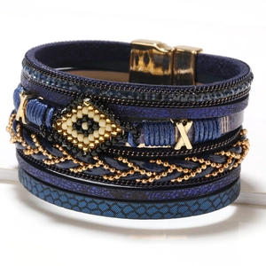 Detail of bohemian evil eye leather wrap bracelet with golden magnetic clasp