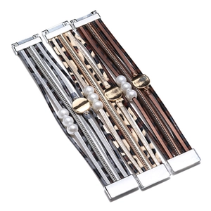 Detail of multi-layer leather bracelets with leopard print, faux pearls and magnetic clasp