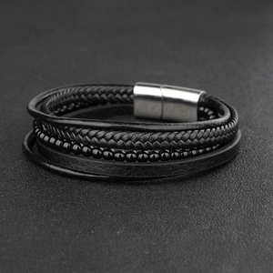 Detail of multi-layer braided black leather bracelet with magnetic steel clasp and beads